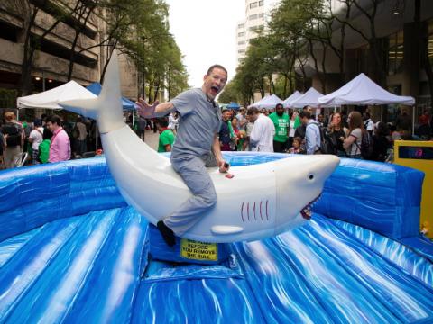 A man riding an inflatable shark